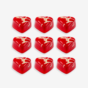 Red heart-shaped candies with white swirl patterns on a white background